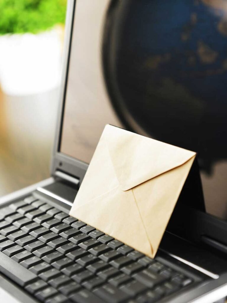 Email Marketing - più Tear con una busta sopra la tastiera