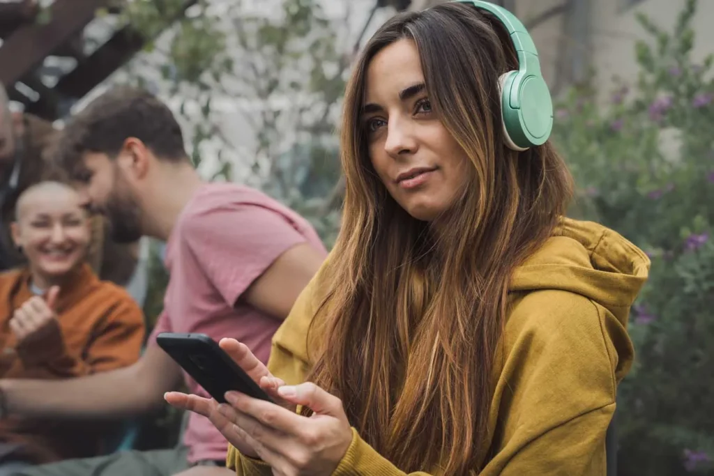 Guida alla creazione di strategie di crescita aziendale per dominare il mercato 10 Social Listening Giovane ragazza con cuffie che osserva