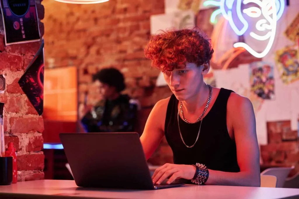 gamification marketing giovane ragazzo con il suo computer portatile seduto al bar