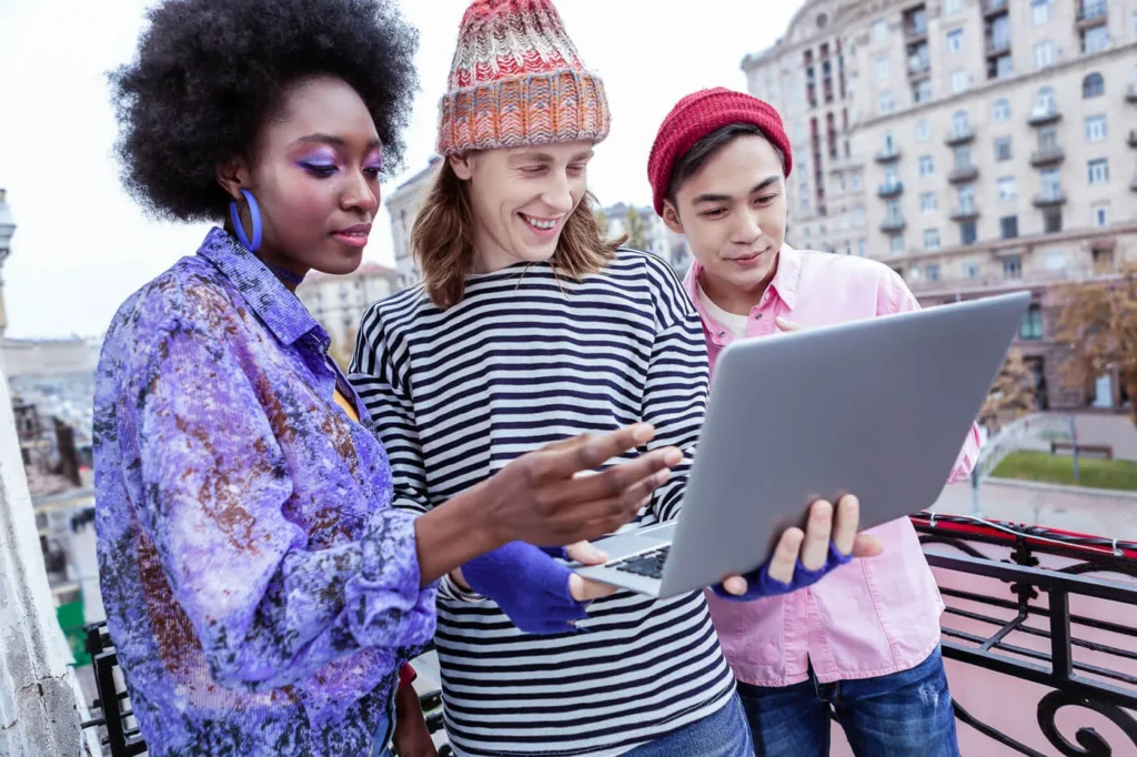 Creare una Community Intorno al Tuo Brand 9 Community online tre ragazzi in strada che guardano un portatile