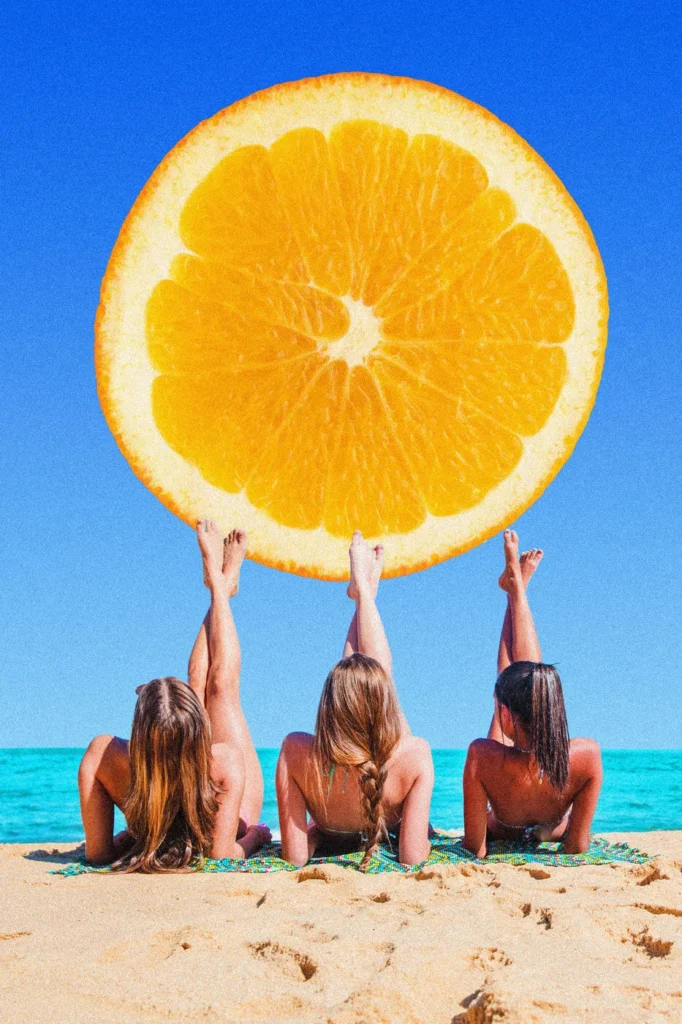 Estate Creativa tre ragazze sdraiate che sorreggono con i piedi un grande limone