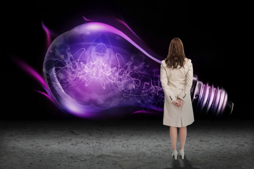 Le Nuove Frontiere dell'Advertising 12 Frontiere dell'Advertising donna di spalle con il soprabito che guarda una grande lampadina