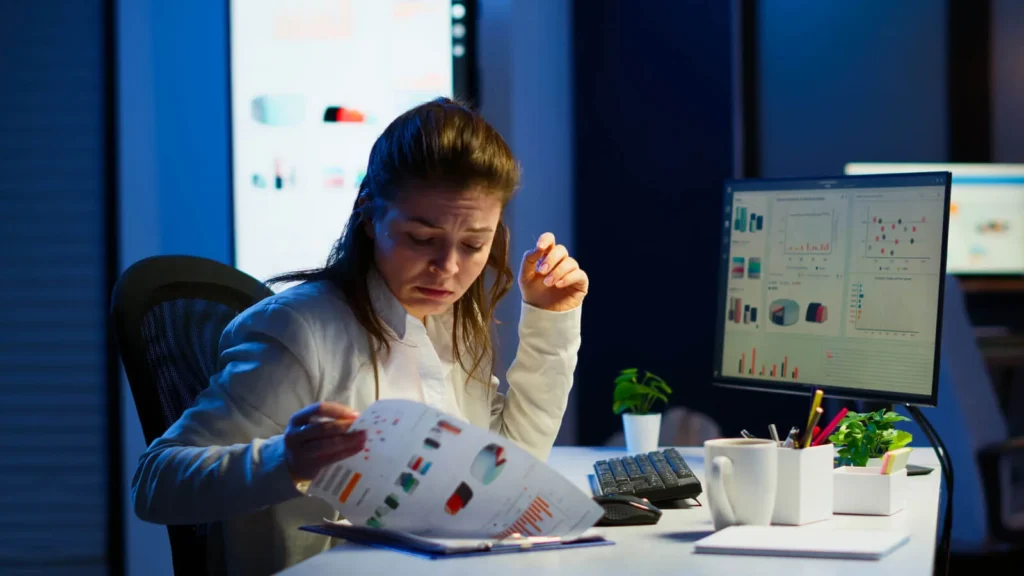 Strategie di Prezzo nel Marketing Digitale 5 Strategie di Prezzo ragazza che spoglia dei grafici sul suo posto di lavoro