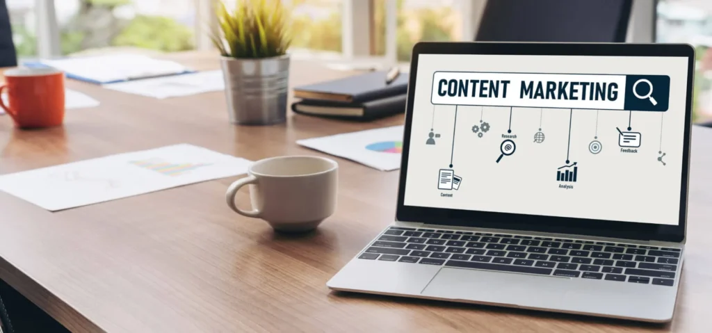 Le Nuove Strategie di Content Marketing efficace 10 Content Marketing efficace Computer portatile sopra la scrivania con a fianco una tassa