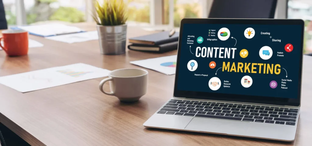 Le Nuove Strategie di Content Marketing efficace 2 Content Marketing efficace Computer portatile sopra la scrivania con due tazze e dei fogli