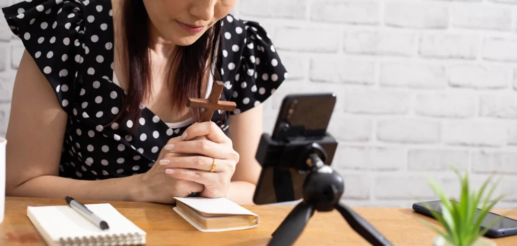 Le Nuove Strategie di Content Marketing efficace 5 Content Marketing efficace ragazza che prega con un crocifisso in mano davanti ha un cellulare