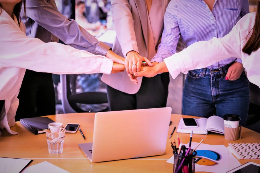 Importanza dei Valori Aziendali nella Comunicazione 6 Importanza dei Valori Aziendali cinque persone che uniscono le mani al centro per fare squadre