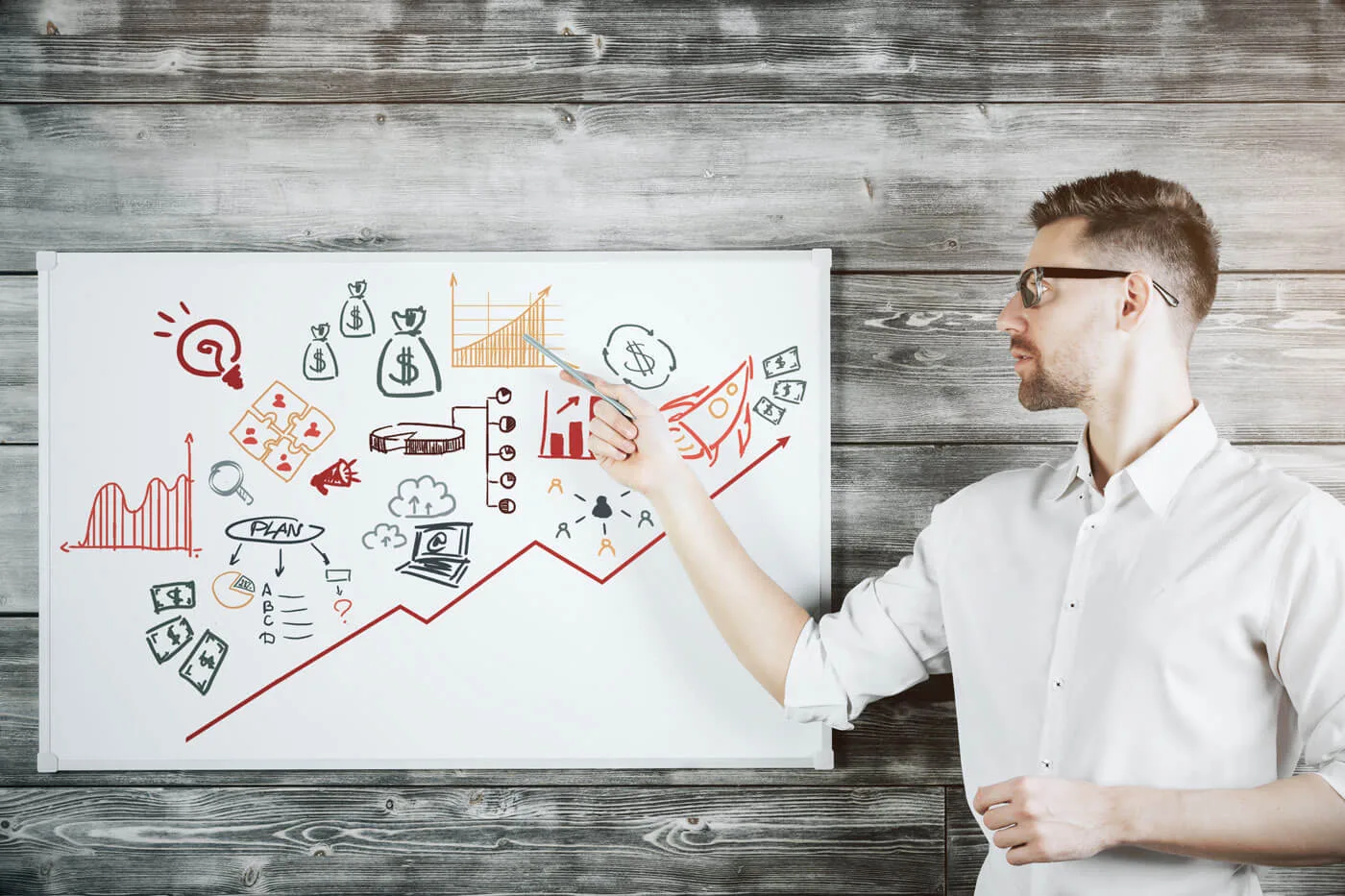 Ristrutturare il Piano di Marketing per il Finale dell'Anno 6 Ristrutturare il Piano di Marketing marketer che indica un grafico su una lavagna bianca