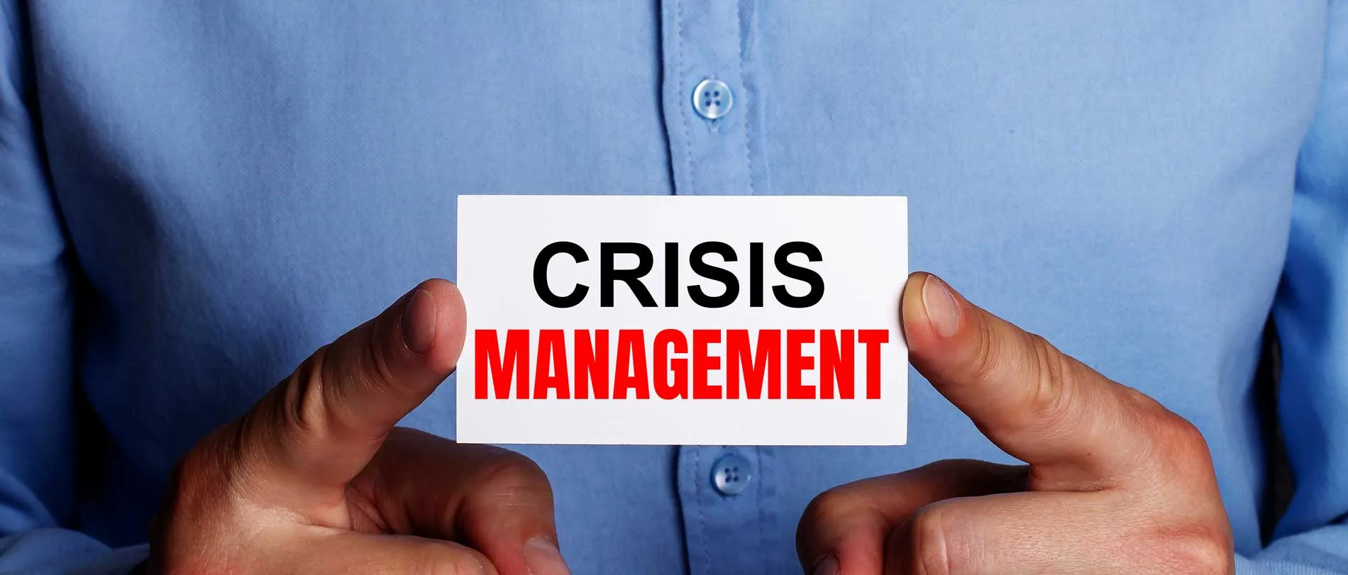 Strategie di Crisis Management 6 Crisis Management mani che stringono un biglietto con su scritto Crisis Management