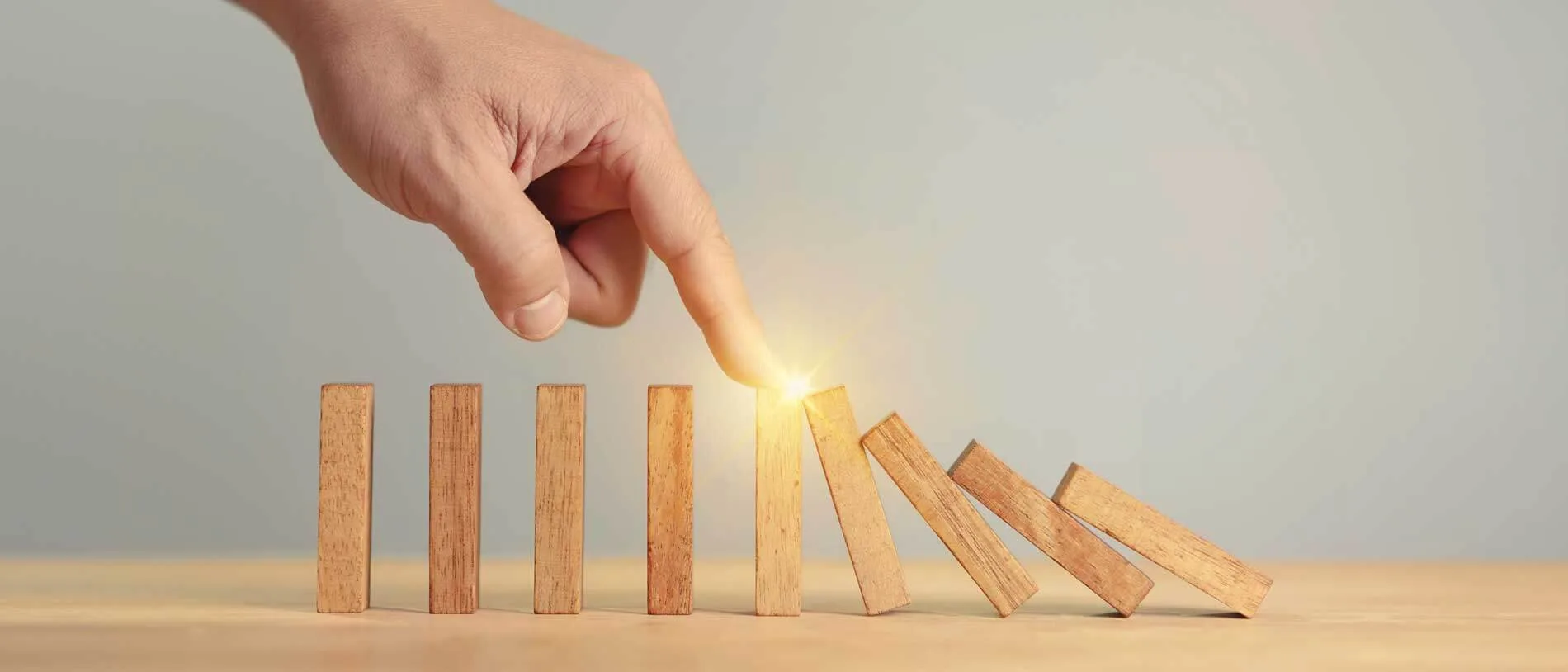 Strategie di Crisis Management 5 Crisis Management mano che ferma con un dito un piccolo domino di legnetti