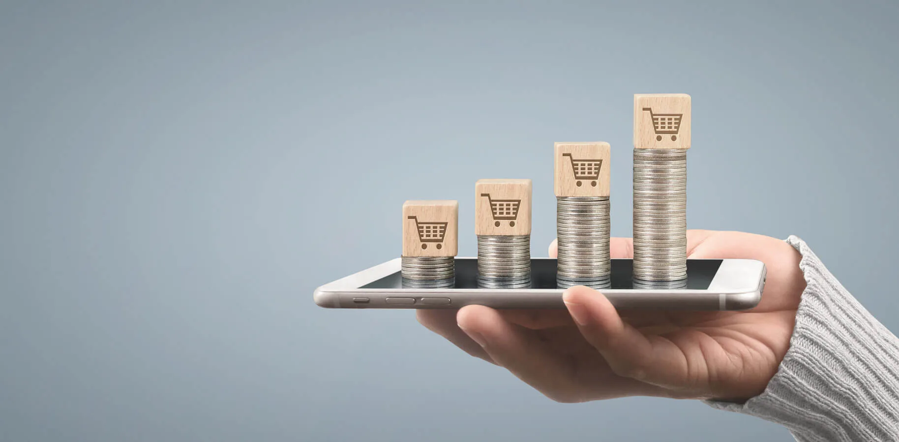 Funnel di Vendita mano che sorregge un cellulare con sopra 4 pile di monete in scala