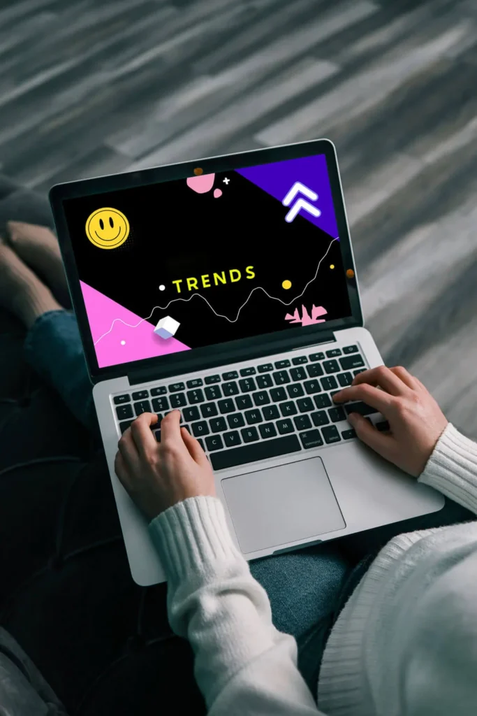 Trend del Marketing 2025 13 Trend del Marketing 2025 mani che scrivono su un computer portatile appoggiato sulle gambe di una persona seduta per terra