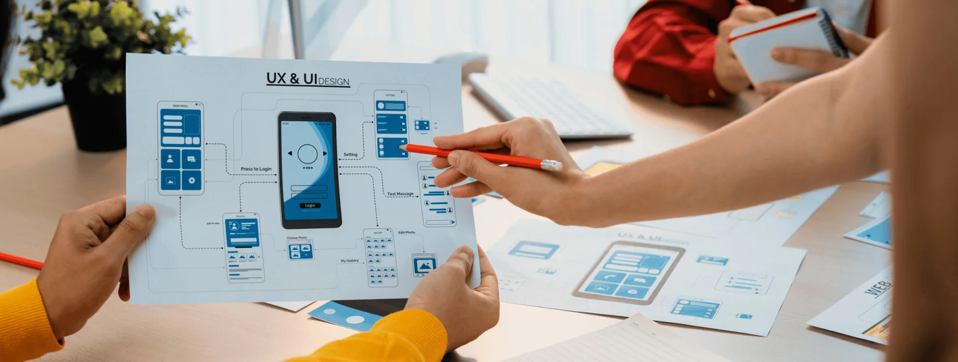 User Experience. Migliorare il Sito Web 7 User Experience persone che discutono un disegno su carta per un template visto su un cellulare UX e UI