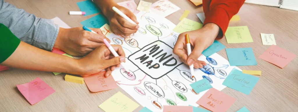 Visual Storytelling mani che scrivono su dei fogli una mappa mentale