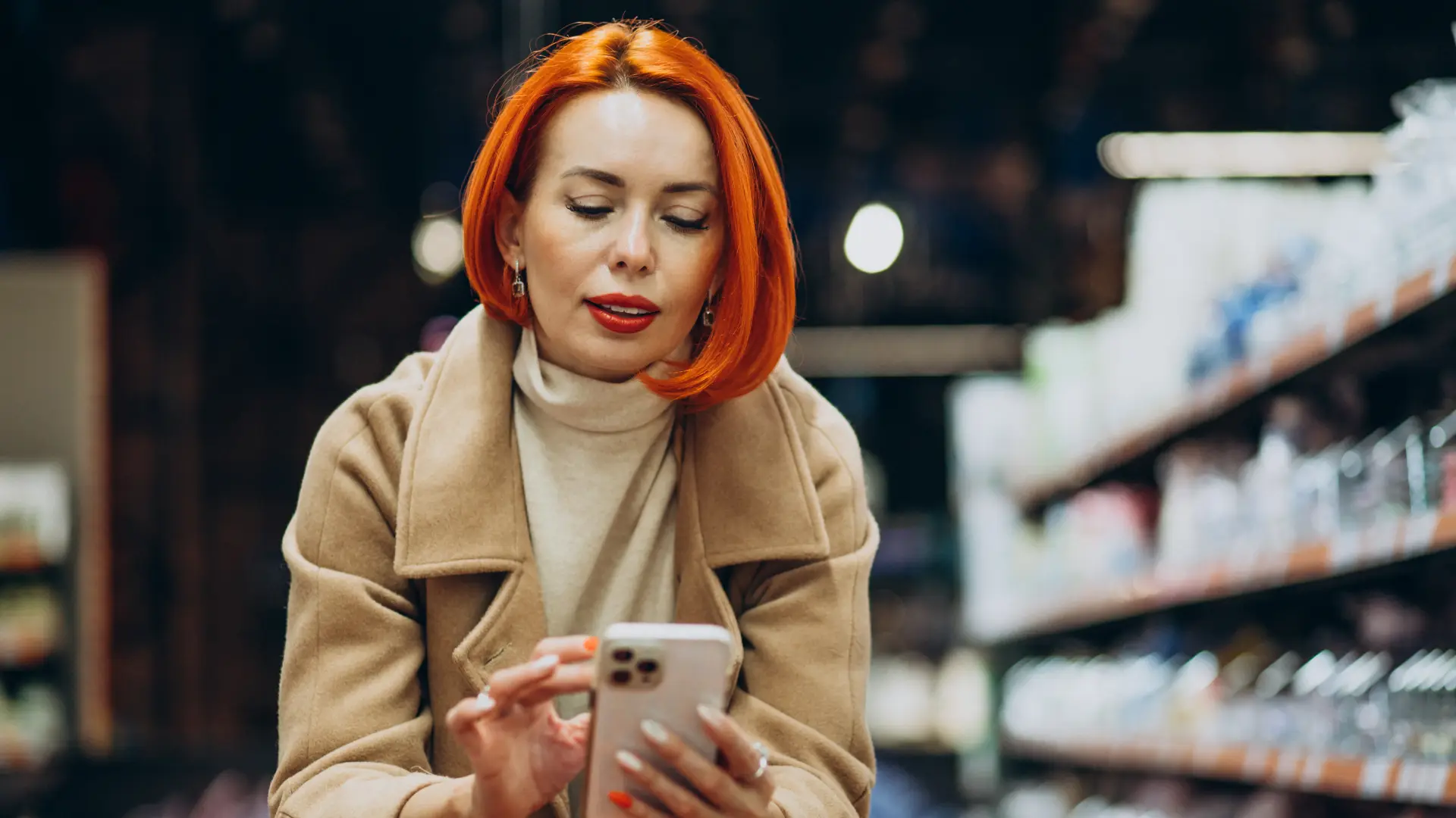 Strategie di Marketing di Prossimità per Negozio Fisico 6 Marketing di Prossimità - donna con il carrello all'interno di un supermercato mentre guarda il sul cellulare